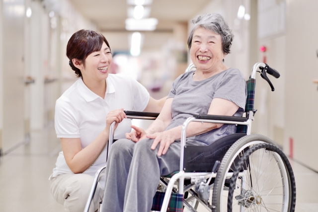 屋内で車椅子に乗っているおばあちゃんと介護士